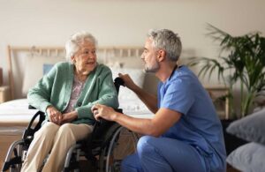 Older adult and caregiver reviewing assisted living costs at a table with papers and a calculator.