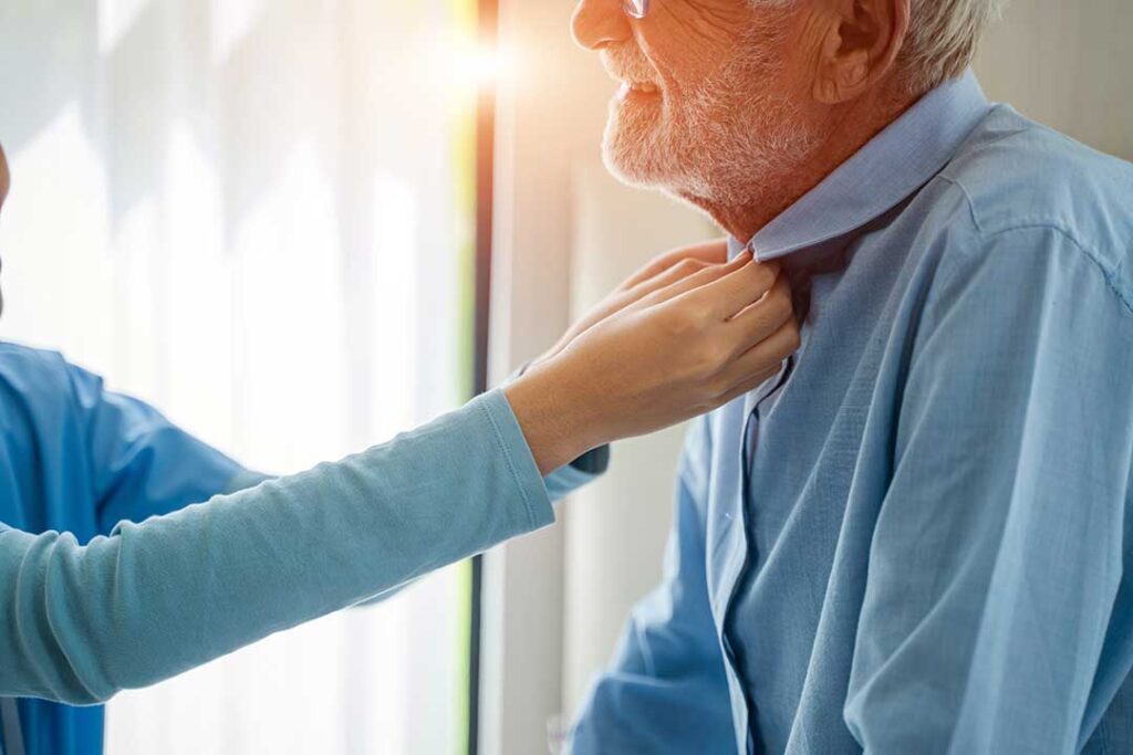 Two family members holding hands across a table during a heartfelt conversation.